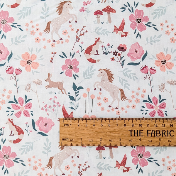 A repeating woodland pattern on a white background, featuring flowers, leaves, mushrooms, foxes, rabbits, deer, birds, and small floral motifs.  The ruler shows the scale of print.