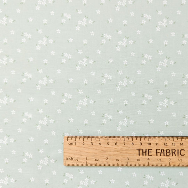 Flowerets - A soft sage green fabric with delicate clusters of tiny white flowers and leaves.