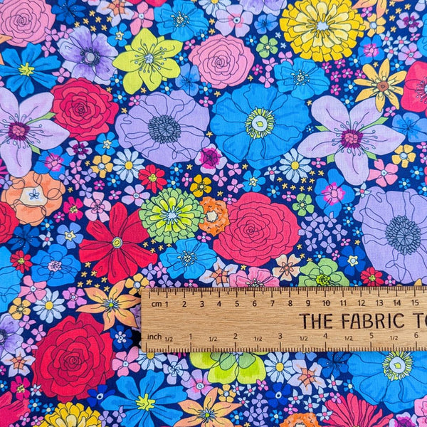 Rainbow Garden fabric: Colorful floral pattern on a dark blue background with ruler for scale