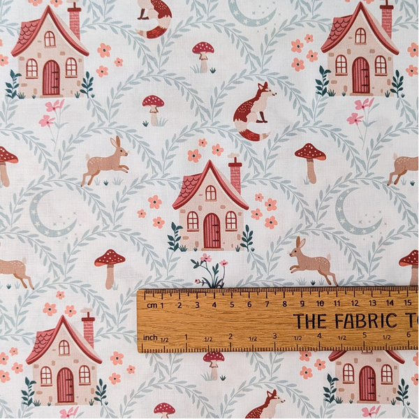A repeating pattern featuring small houses and woodland animals, with leafy vines on a white background.  The ruler shows the scale of print.